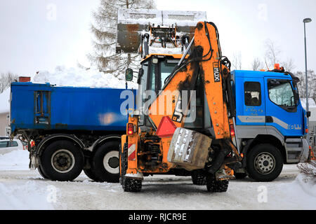 Salo, Finlande - le 2 février 2019 : la neige sur les charges du chargeur JCB Sisu bleu dump truck trailer pour être transportés à une zone de déversement de la neige. Banque D'Images