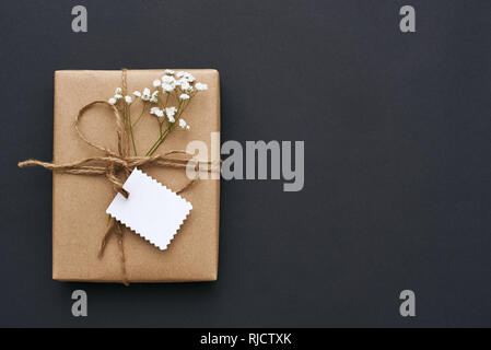 Faire l'amour avec...Des Boîte cadeau, décoré de fleurs sauvages et de petits blancs sur fond sombre carte postale Banque D'Images