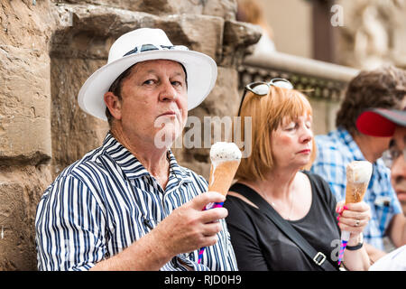 Florence, Italie - 30 août 2018 : Funny man tourist couple eating ice cream cone gelato à Florence dans la rue avec beaucoup de gens foule sur sunny Banque D'Images