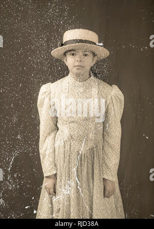 Photo officielle antique réplique avec la poussière et les rayures de petite fille en 1900, les vêtements. Banque D'Images