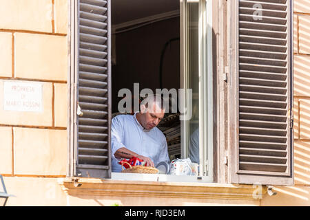 Rome, Italie - le 4 septembre 2018 : Closeup portrait de l'homme italien en dehors de chef par fenêtre ouverte à la cuisson des aliments petit déjeuner en matinée sur la rue dans la ville historique de c Banque D'Images