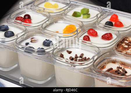 Gros plan du yogourt maison dans des bocaux en verre avec différents types de garnitures. L'alimentation saine Banque D'Images