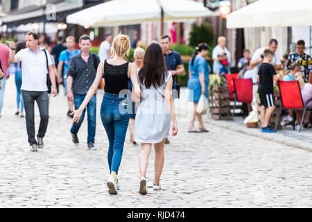 Lviv, Ukraine - le 30 juillet 2018 : la ville de Lvov polonais ukrainien historique durant la journée avec deux filles friends holding hands walking par outdoor cafe restaurant Banque D'Images