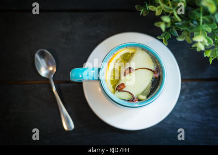 Sex boisson alcoolisée. Whiskey avec du jus de pomme et d'épices anis, girofle, cannelle, citron dans une tasse bleue. Banque D'Images