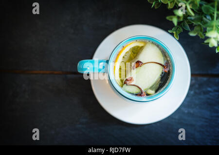 Sex boisson alcoolisée. Whiskey avec du jus de pomme et d'épices anis, girofle, cannelle, citron dans une tasse bleue. Banque D'Images