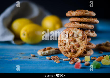 Biscuits orange ronde avec des fruits confits et une tranche d'orange juteuse allongé sur une table en bois Banque D'Images