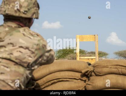 Un soldat de l'Armée américaine affecté à la Force opérationnelle interarmées - Corne de l'Afrique lance une grenade de formation à travers une vitre en préparation pour un expert Infantryman Badge (BEI) Évaluation au Camp Lemonnier, Djibouti, le 23 janvier 2018. La BEI est une des compétences particulières d'un insigne qui exige de l'infanterie à passer cinq jours d'évaluation qui se compose d'un test de condition physique de l'armée, jour et nuit, la navigation terrestre, une marche forcée de 12 km, et 30 tâches individuelles couvrant les armes, medical, patrouille de sécurité et de compétences. En avril 2016 une itération de la BEI au Camp Lemonnier, seulement 15 pour cent des candidats a gagné t Banque D'Images