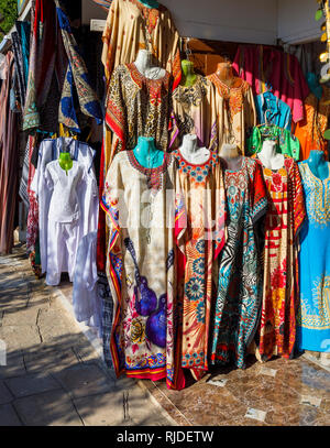 Afficher dans une échoppe de marché, sur les rives du Nil par le Temple de Kom Ombo, des couleurs traditionnelles galabeyas pour vente comme souvenirs touristiques Banque D'Images