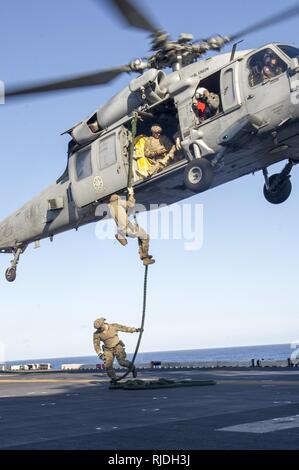 Océan Pacifique (jan. 20, 2017) Les membres affectés à l'unité mobile de destruction des engins explosifs (EODMU) 11 corde rapide d'un MH60S Knight Hawk affecté à la "Black Knights" de l'Escadron d'hélicoptères de combat de la mer (HSC) 4 sur le pont d'envol du navire d'assaut amphibie USS America (LHA 6) au cours d'un exercice de passage (PASSEX) avec la classe Nimitz porte-avions USS Carl Vinson (CVN 70). Amérique latine, une partie de l'Amérique du groupe amphibie, à 15e Marine Expeditionary Unit, est de retour d'un déploiement de 7 mois aux États-Unis 3e, 5e et 7e flotte secteurs d'opérations. Banque D'Images