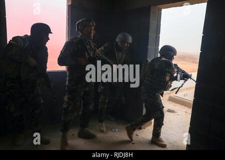 Les membres des forces de sécurité iraquiennes's Brigade 61e un bâtiment clair des forces opposées au cours de l'activité de formation qui a abouti au Camp Taji, l'Iraq, le 22 janvier 2018. Le programme à développer et à améliorer la capacité des partenaires nationaux comprend : le leadership, l'éthique et droit de la guerre et la formation. De plus, les recrues sont enseignées la navigation terrestre, la formation médicale de base, les compétences de l'infanterie et des petites unités tactiques. Banque D'Images