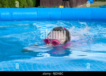 Un jeune nageur courageux plongées dans une piscine dans le jardin. C'est une chaude après-midi d'été. Banque D'Images