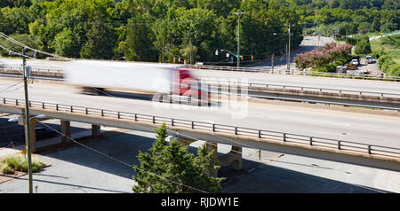 Un semi truck crossing sur un pont pris avec vitesse d'obturation lente pour montrer le mouvement et la vitesse. Banque D'Images