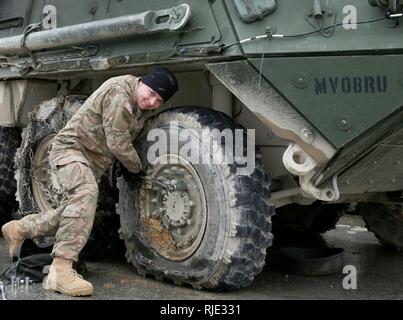 Un soldat de l'Armée américaine du 2e Escadron, 2e régiment de cavalerie (2CR) effectue des mesures d'entretien sur un M1126 Stryker véhicule porteur d'infanterie alliées au cours de l'esprit VIII dans la zone d'entraînement de Hohenfels, Hohenfels, Allemagne, le 20 janvier 2018. Esprit alliées VIII comprend environ 4 100 participants de 10 nations à l'instruction de l'Armée de la 7e commande Hohenfels Zone d'entraînement, 15 janv.-fév. 5, 2018. Spirit est un allié de l'armée américaine l'Europe-dirigé un exercice multinational série conçue pour développer et renforcer l'OTAN et partenaire clé de l'interopérabilité et l'état de préparation. Banque D'Images