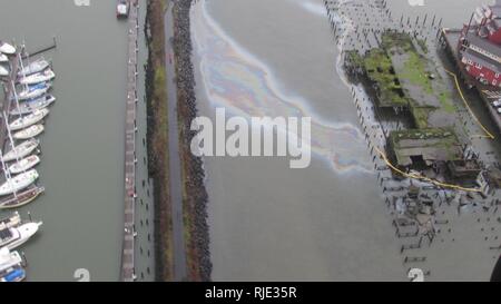 De confinement est mis autour de divers domaines autour d'une jetée délabrée pour empêcher la propagation d'un reflet brillant sur la surface de la rivière Columbia, à Astoria, Oregon, le 20 janvier 2018. Division de la gestion de l'incident de la Garde côtière canadienne sont sur les lieux de l'Astoria et diriger les efforts de nettoyage par le personnel contractuel de plongée mondiale et de récupération. Banque D'Images