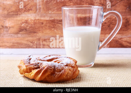 Crème au chocolat et sucre en poudre pâte de verre et joints toriques avec du lait sur la table en bois. Petit-déjeuner traditionnel. Banque D'Images