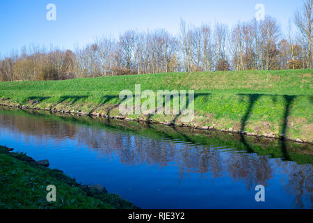 Les ombres de la fée électricité sous-station Lane towers distributions comme vu sur la rive de la rivière Mersey. L'ombre 5 pi panneaux. Banque D'Images