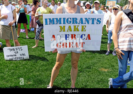 Une femme est titulaire d'un grand signe de l'Amérique que les immigrants apportent à un rassemblement contre l'emporter sur les politiques d'immigration en centre-ville de Cleveland, Ohio, USA le 30 juin 2018. Banque D'Images