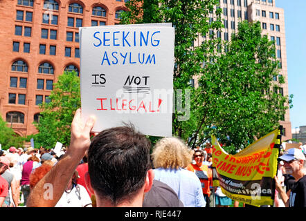 «Vers l'asile n'est pas illégal' signe est tenue par un homme à une protestation le 30 juin 2018 à Cleveland, Ohio, USA Le rallye contre Trump les politiques d'immigration. Banque D'Images