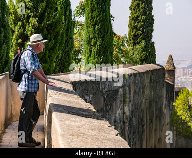 Hauts homme portant chapeau Panama marche sur l'enceinte fortifiée, Alcazaba, Malaga, Andalousie, Espagne Banque D'Images