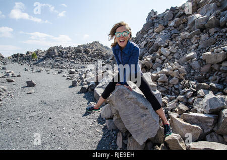 Femme adulte chevauche sur les roches à l'Obsidian Dome trail in California's eastern sierra, près de Mammoth Lakes. Banque D'Images