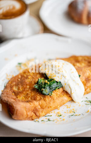 Le petit-déjeuner. La Frittata italienne - omelette. Omelette aux tomates, avocat, épinards et fromage à pâte molle. Des croissants, du café et d'autres plats sur la table en Banque D'Images