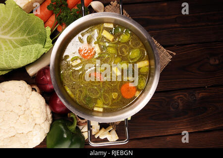 Bouillon avec carottes, oignons divers légumes frais dans un pot - frais colorés clear spring soupe. Cuisine végétarienne paysage rural bouillon Banque D'Images