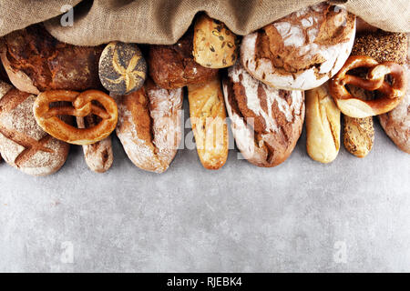 Assortiment de pain frais et des petits pains sur table en pierre historique. Concept de l'affiche de boulangerie Banque D'Images