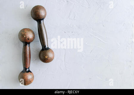 Vieux métal rouillé haltères rétro pour le sport. Sur un fond gris. Close-up. Banque D'Images