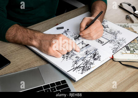 Focus sélectif de mans mains dessin dans l'album sur la table en bois à côté du coffre Banque D'Images