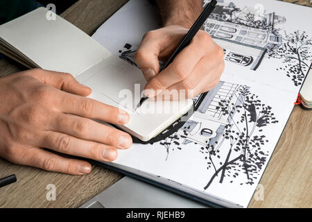 Focus sélectif de mans mains dimensions dans l'ordinateur portable sur une table en bois à côté d'album Banque D'Images