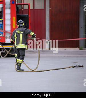 Italia, IT, Italie - 10 mai 2018 : l'Italien pompier dans unifiorm avec aaction et texte Vigili del fuoco pompiers cela signifie en langue italienne à fir Banque D'Images