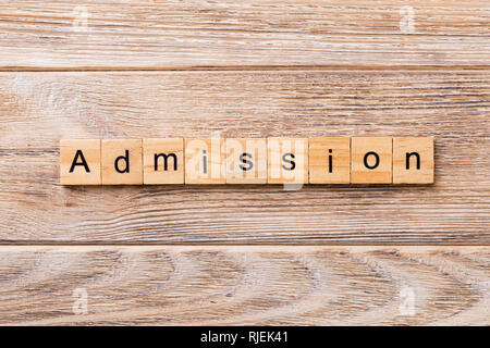 ADMISSION mot écrit sur une cale en bois. Texte sur l'admission de votre table en bois, design concept. Banque D'Images