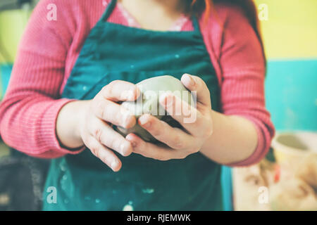 Portrait de l'artiste féminine de la pâte à modeler avec les mains à l'atelier de poterie. Banque D'Images