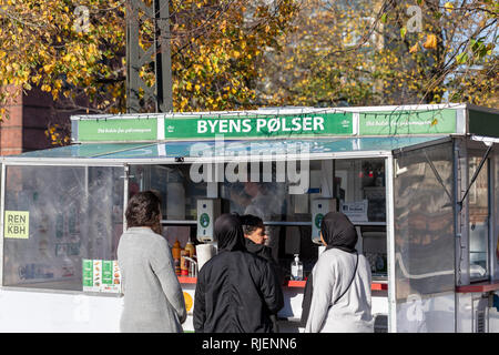 La femme en face d'un stand hotdog halal, 'Byens Pølser" ('La Ville') ; Saucisses Nordvest, Copenhague, Danemark Banque D'Images