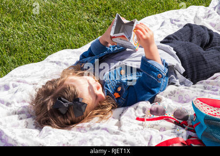 Enfant de manger des collations sur blanket au soleil Banque D'Images