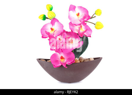 Orchidée artificielle rose en vase isolé sur fond blanc. Banque D'Images