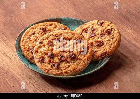 Une photo gros plan de cookies aux pépites de chocolat sur un fond de bois rustique foncé Banque D'Images