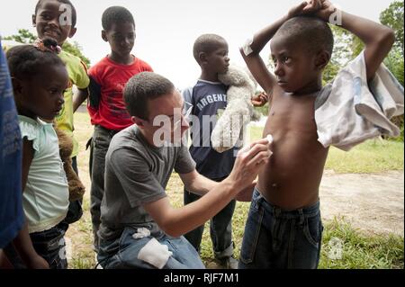 Maître de 3e classe Lee McGraw, hôpital corpsman, de Johnstown, Pa., aide à nettoyer et panser une plaie sur un garçon d'un petit village près de Bahia Malaga Base navale, la Colombie tandis que marins et Marines de la station de transport amphibie USS New Orleans mener un projet de relations communautaires. La Nouvelle Orléans est sur un port visiter pendant le sud de la gare de partenariat 2010. Partenariat sud Station est un déploiement militaire américain annuel de formation des équipes pour le Commandement Sud des États-Unis zone de responsabilité. Banque D'Images