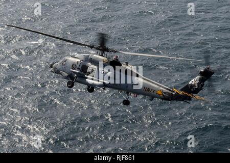 U.S. 5ÈME ZONE DE RESPONSABILITÉ DE LA FLOTTE (fév. 15, 2013) Un Sea Hawk MH-60R à partir de l'hélicoptère de rapaces grève Maritime Squadron (HSM) attribué à 71 le porte-avions USS JOHN C. STENNIS (CVN 74) pratiques un virage serré à droite. John C. Stennis est déployé sur le 5e Flotte des États-Unis zone de responsabilité des opérations de sécurité maritime, les efforts de coopération en matière de sécurité dans le théâtre et missions d'appui pour l'opération Enduring Freedom. Banque D'Images