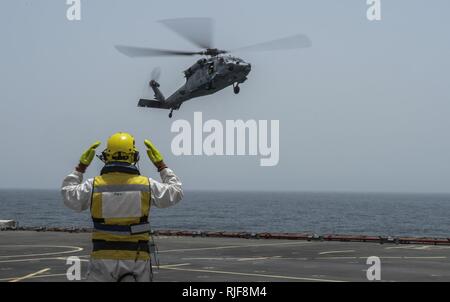 Les navires l'Adjudant Steve Cooper signaux pour le SH-60 Sea Hawk, un hélicoptère de combat Mer 26 Escadron basé à Norfolk, en Virginie, à la terre à bord de la Baie de Cardigan RFC pour un transfert des passagers dans le cadre de l'exercice international de la lutte contre les mines (IMCMEX) 13. IMCMEX marines comprend de plus de 40 pays dont l'objectif est de promouvoir la sécurité régionale par les opérations de lutte contre les mines dans la 5e flotte des États-Unis zone de responsabilité. Banque D'Images