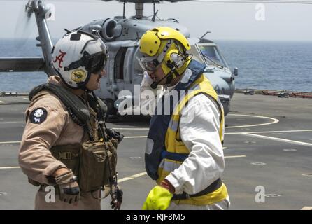 Les navires l'Adjudant Steve Cooper parle avec un membre de l'équipe de SH-60 Sea Hawk, un hélicoptère de combat Mer 26 Escadron basé à Norfolk, au cours d'un transfert de passagers à bord de la Baie de Cardigan RFC dans le cadre de l'exercice international de la lutte contre les mines (IMCMEX) 13. IMCMEX marines comprend de plus de 40 pays dont l'objectif est de promouvoir la sécurité régionale par les opérations de lutte contre les mines dans la 5e flotte des États-Unis zone de responsabilité. Banque D'Images