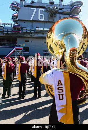 Le Arizona State University Marching Band effectue pour les marins à l'avant du porte-avions USS Ronald Reagan (CVN 76) au cours d'une "Bataille des groupes" dans le cadre de la Marine et le Marine Corps Maison de vacances Bol Déjeuner. Le navire a accueilli le déjeuner pour les joueurs de la Sun Devils de Arizona State University et le rouge les aventuriers de la Texas Tech University. Les équipes jouent dans le 36e Congrès annuel de l'Université National Bowl le 30 décembre au Stade Qualcomm de San Diego. Banque D'Images