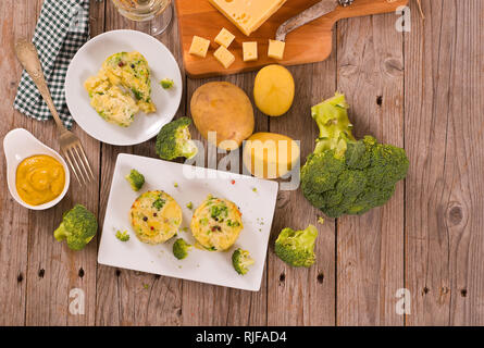 Les gratins de pommes de terre avec des fleurons de brocoli.
