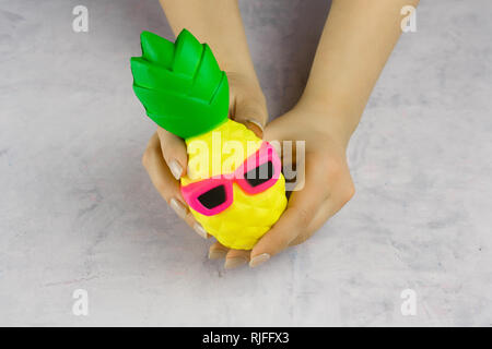 Femme avec les mains anti stress toy pineapple in sunglasses Banque D'Images