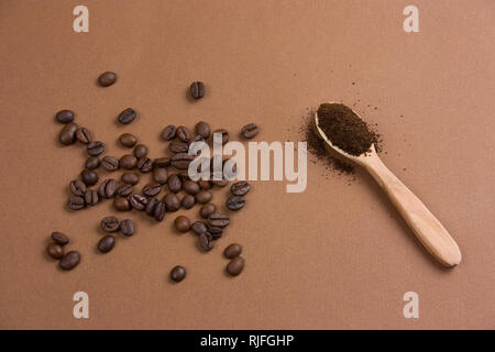 Vue de dessus les grains de café et de café dans une cuillère de bois sur un fond brun Banque D'Images