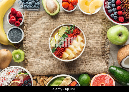 Vue de dessus du smoothie bols et cadre fait d'ingrédients frais sur le sac Banque D'Images