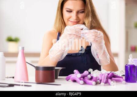 Jeune femme avec les bigoudis à barbershop Banque D'Images