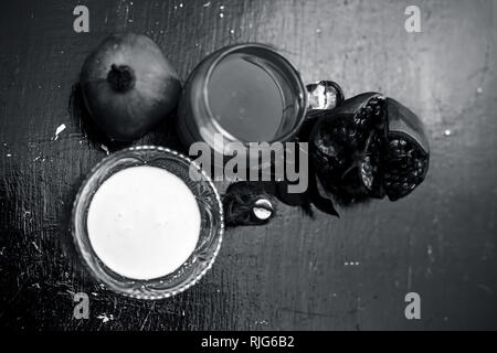 Close up de sharbat grenade ou de jus avec du lait,essence,Grenade et de sucre brut de la grenade sur la surface en bois. Banque D'Images