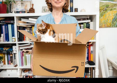 PARIS, FRANCE - Nov 4, 2018 : femme unboxing carton avec cat à l'intérieur - nouvelle livraison de Amazon site e-shopping Banque D'Images