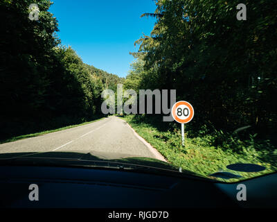 New French 80kmph vu chanter de limite de vitesse sur une voie publique de la forêt. À compter du 1 er juillet 2018, la limite de vitesse sur les routes à deux voies de 90 à 80 KMPH KMPH, dans l'espoir répondre augmentation alarmante du nombre de victimes de la route Banque D'Images